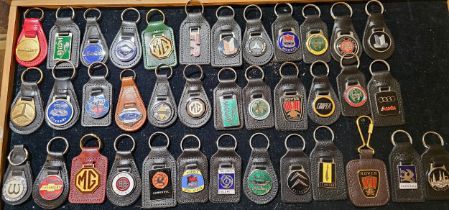 A collection of metal and enamel car key fobs