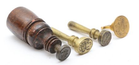 Three brass hand seals and a mahogany hand seal