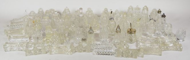 A large quantity of cut and pressed glass cruet sets, together with two cranberry glass vases.