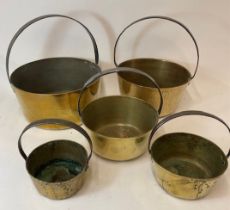A graduating set of five early 20th century brass and iron handled jam pans, largest 32cm diameter.