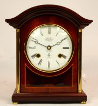A modern inlaid mahogany mantel clock, having 8 day movement striking on bell, 23cm tall.