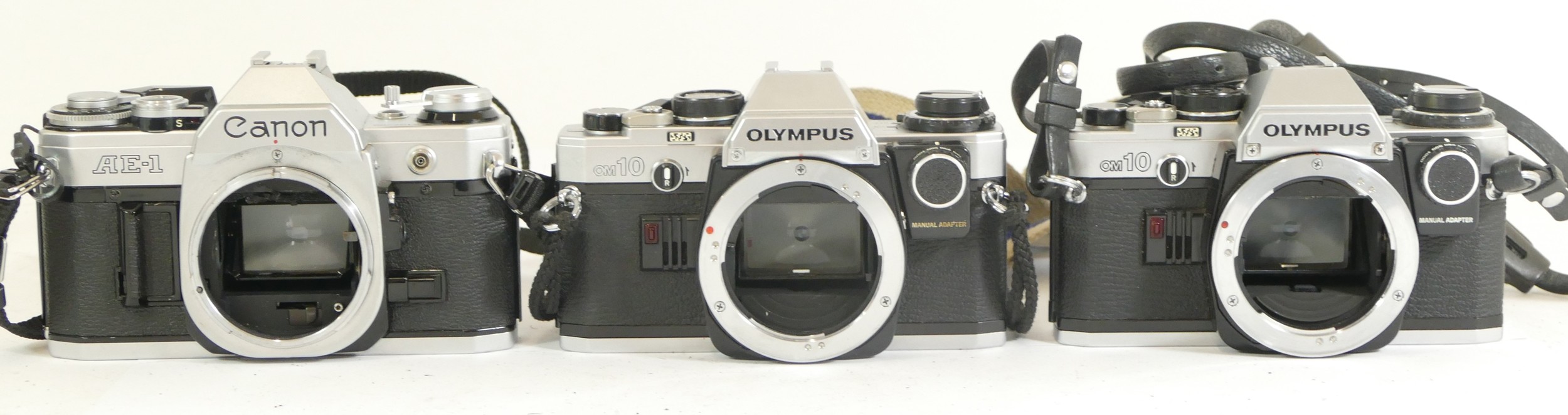 Three assorted cameras to comprising of two Olympus OM10 camera bodies and a Canon AE-1 camera