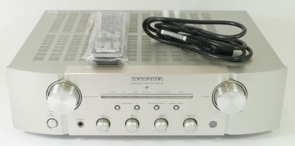 Marantz, a silver PM7004 amplifier, with power lead and remote. .