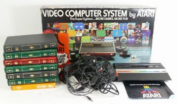 A boxed Atari 2600 games console unit, together with various games cassettes and control units