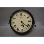 An early 20th century painted brass Smiths factory clock, having 8 day movement, with glass door and