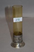 A silver and glass stem vase having cylindrical amber glass vase in a moulded silver base,