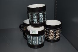Four Ambleside pottery mugs.