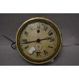 An early 20th century brass cased clock, having glass door and painted tin face with Roman numerals,