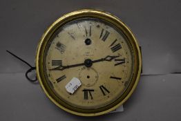 An early 20th century brass cased clock, having glass door and painted tin face with Roman numerals,
