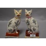 A pair of Wemyss style cat studies, having foliate patterns with ribbons tied round necks.