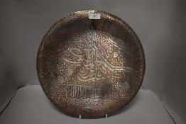An Islamic plated copper charger having Islamic/Arabic script.