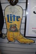 A mid century tin pressed advertising sign for Miller Light beer in the form of a cow boy boot.