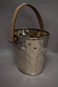 A hammered effect champagne bucket having leatherette handle.