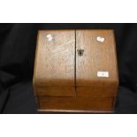 An early 20th century oak stationary box having internal shelving, void of escutcheon and key.