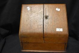 An early 20th century oak stationary box having internal shelving, void of escutcheon and key.