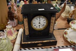 A Victorian French mantel clock having marble column inserts and enamel dial