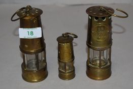 Three miniature replica brass Davy lamps.