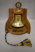 A memorial Rotary international presentation bell on wooden stand, in memory of John Kornelson,