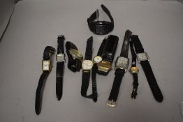 A selection of wrist watches all having black straps.