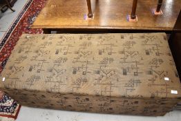 A vintage upholstered ottoman bedding chest having wood frame