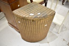 A vintage Lloyd Loom corner linen basket