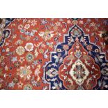 A traditional carpet square, red ground with blue foliate pattern, approx. 310 x 240cm