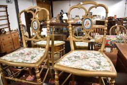 Two Victorian painted bedroom chairs having painted ceramic back panels with cherub decoration