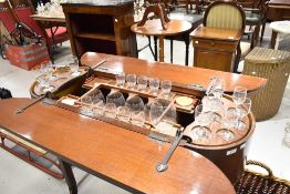 A vintage sapele fold out cocktail trolley including some contents