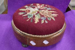 An embroidered circular footstool.