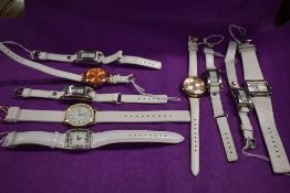 Ten ladies/girls fashion watches, all having white straps.