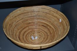 A large modern rattan bowl, of circular form constructed by traditional techniques.