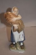 A Royal Copenhagen (Denmark) figurine, depicting a young girl holding a bushel, number 908, printed,