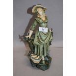 A Victorian German porcelain figure of a fish seller having a Royal Dux style glaze with slight