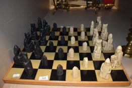 A modern cast-resin medieval themed chess set and board