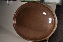 An oval copper tray with bead moulded edge detail