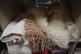 A group of three material throws and one sheepskin style rug