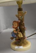 A vintage Geobel Hummel table lamp of a girl sat in an apple tree in good condition
