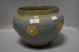 An early 20th century Royal Doulton Jardiniere with embossed flower design and blue stone ware