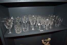 A selection of cut-crystal drinking glasses, tumblers, wine glasses, mostly of conforming designs.
