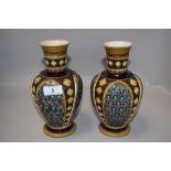 A pair of Victorian Mettlach vases having impressed ceramic design with hand decorated panels,