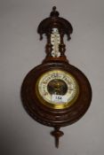 An early 20th century carved mahogany barometer, with milk glass thermometer scale