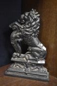 A cast-iron lion rampant fire ornament, with scroll decorated plinth base,