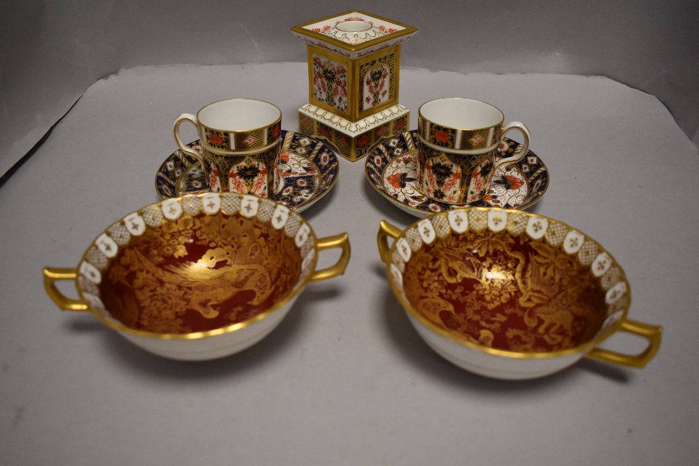 A Royal Crown Derby 1128 pattern socle form candlestick, two matching coffee cans and Imari