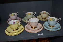 A harlequin set of six Cavour Ware trios, each with muted colours and gilt enriched rims