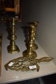 A cast-brass iron stand or trivet, sold together with three brass candlesticks.