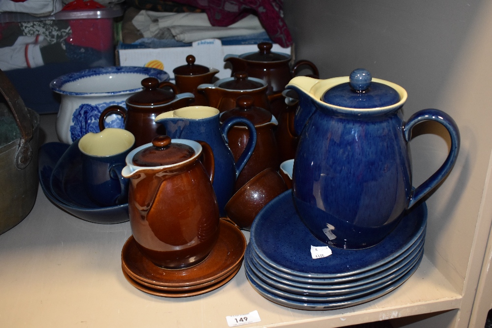 A group of Denby stoneware jugs and teapots, some saucers and plates, in blues and browns