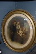 An early 20th century family photo portrait in an ornate oval gilt and gesso frame.