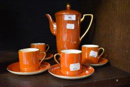 A Crown Devon lustrous orange four setting coffee set, with coffee pot.