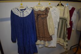 A selection of predominantly 1970s girls dresses, various styles and colours.
