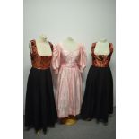 Three vintage Dirndl dresses, one in pink and two in black with iridescent copper coloured bodices
